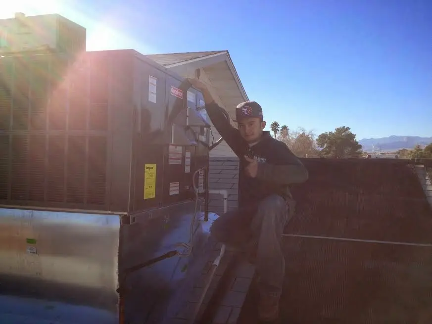 HVAC technician performing HVAC Inspection on a rooftop unit in Kittery
